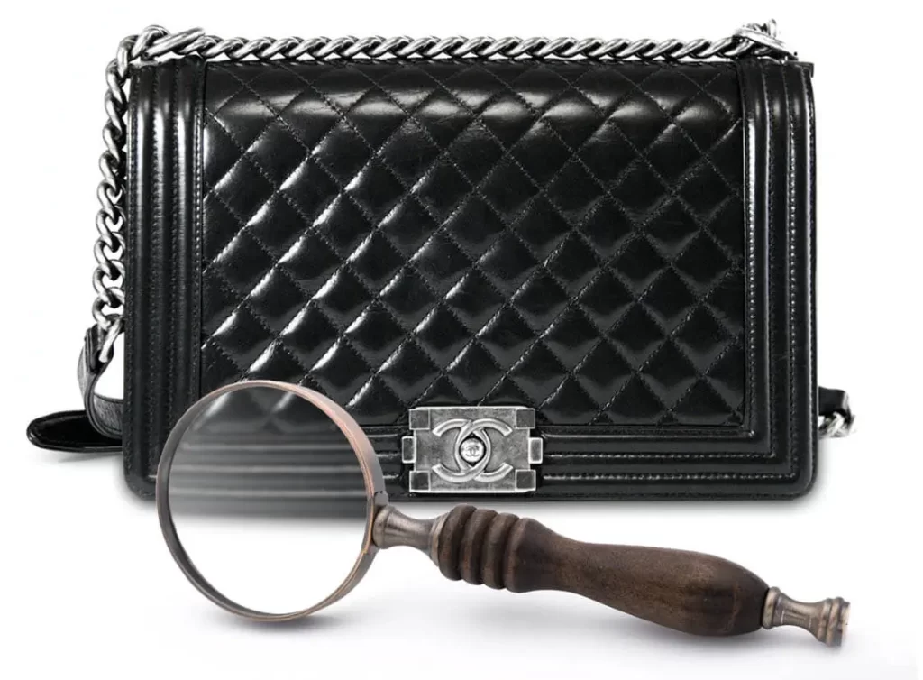 Prüfung einer Chanel Tasche mit Lupe